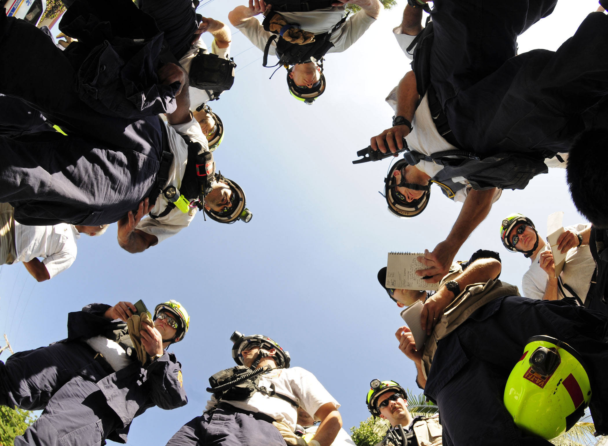 Urban Search and Rescue Team, with assistance from U.S. military personnel, coordinate plans before a search and rescue mission